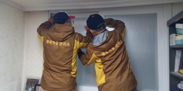 5. 유림동 행복마을관리소 마을지킴이들이 취약계층의 따뜻한 겨울나기를 위해 뽁뽁이를 붙이고 있다..jpg